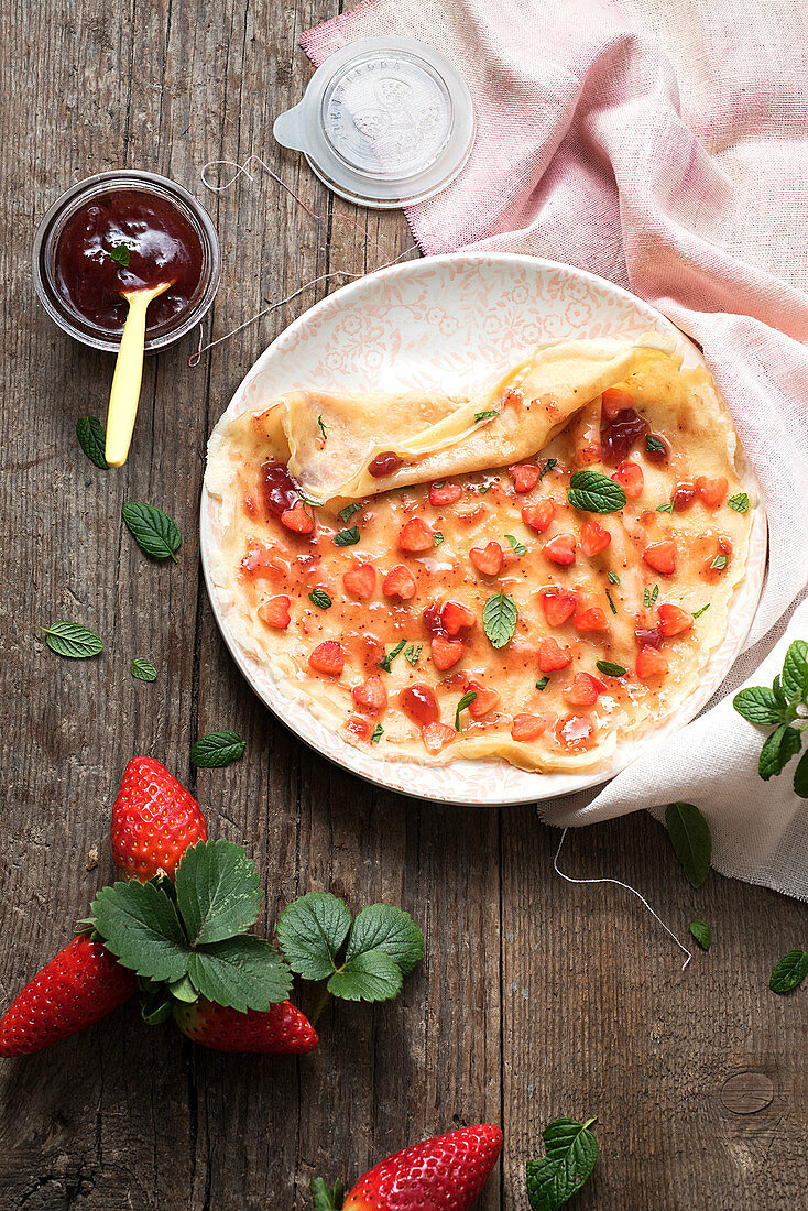 Crepes with jam, strawberries and mint