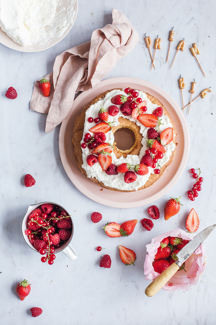 Ringförmiger Geburtstagskuchen mit Sahne und frischen Beeren