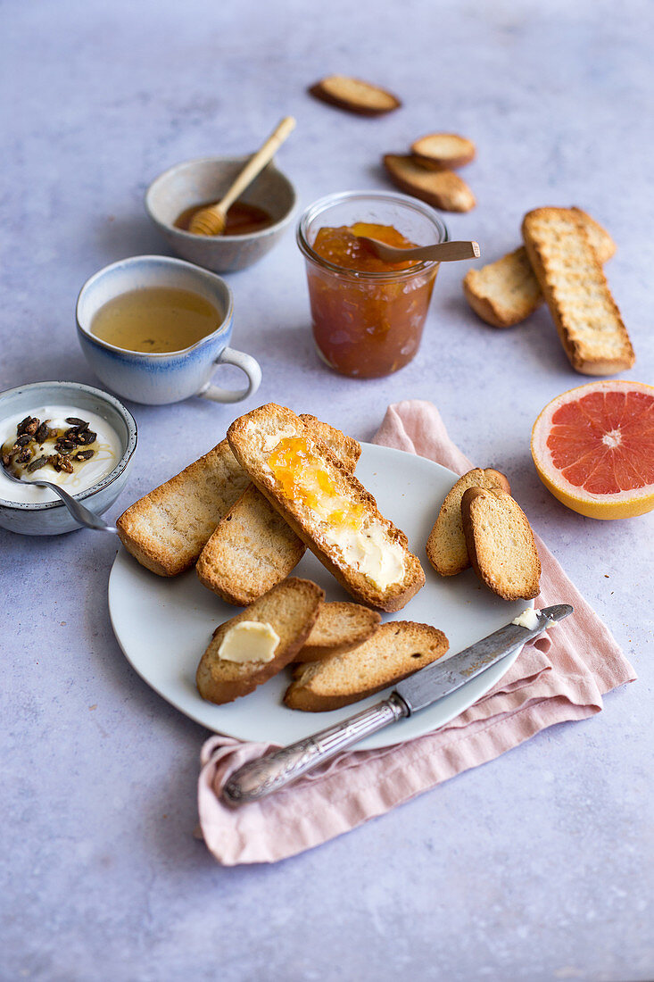 Breakfast with rusks, jam, plain yoghurt, grapefruit and tea