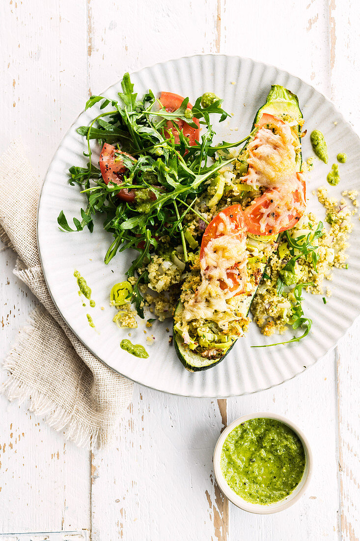 Courgette stuffed with couscous, tomatoes and leek served with rocket salad