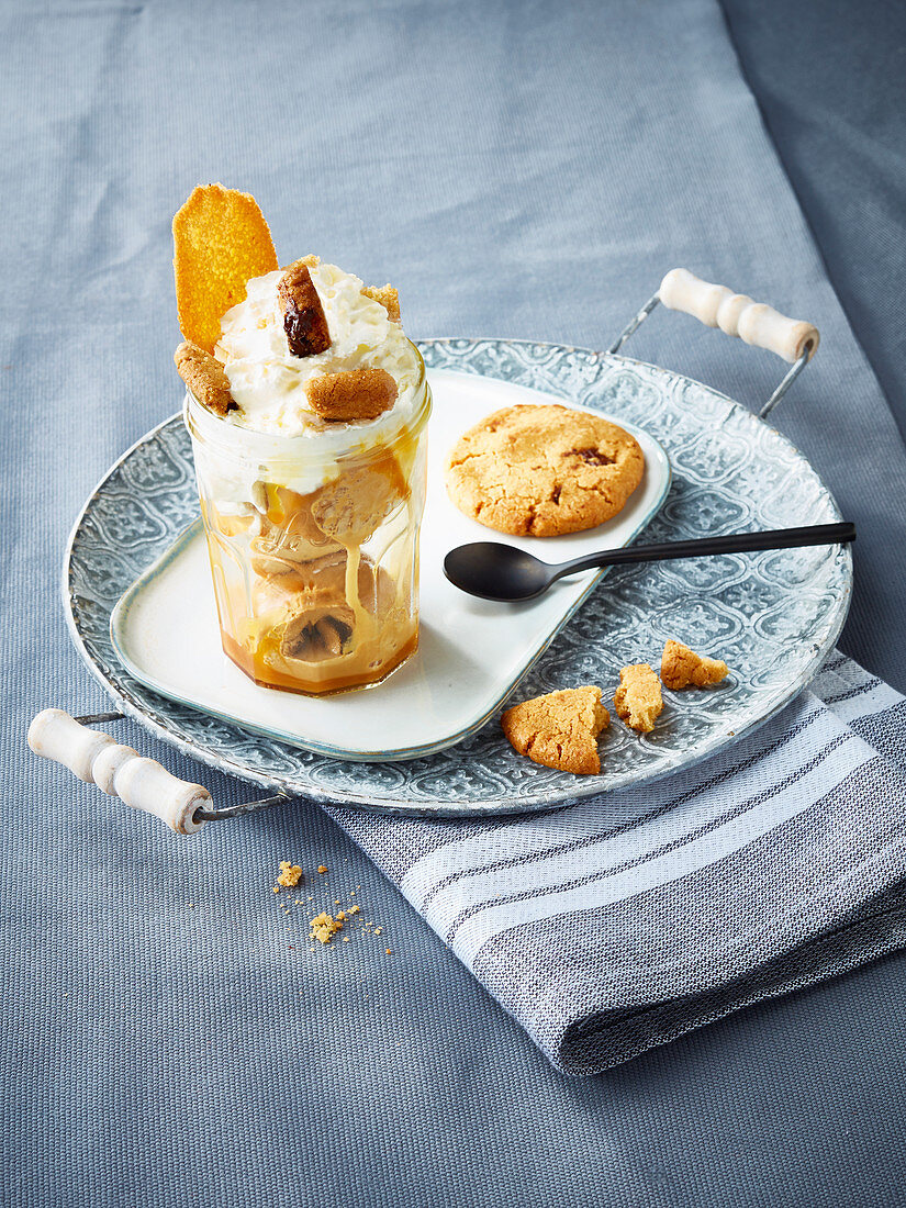Caramel ice cream with whipped cream and biscuits