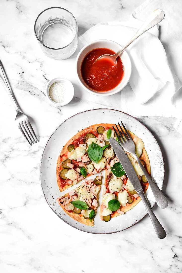 Pizza mit Zucchini, Schinken, Tomaten und Mozzarella