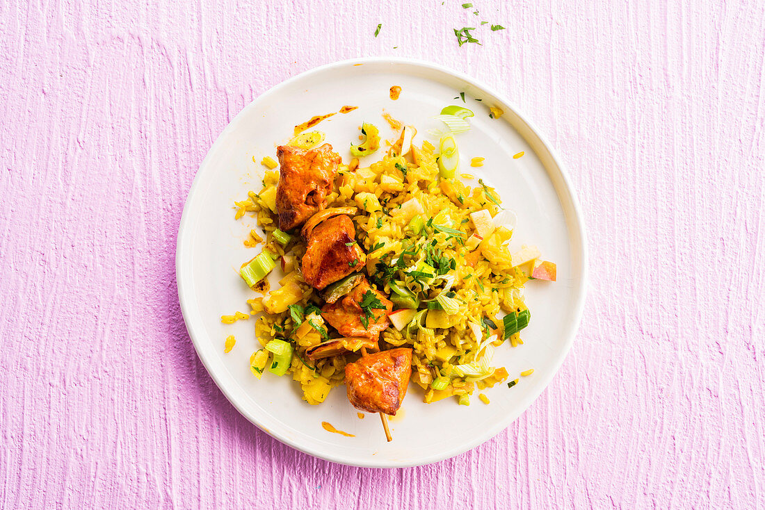 Hühnerspieß auf Curry-Reis mit Apfel und Frühlingszwiebeln