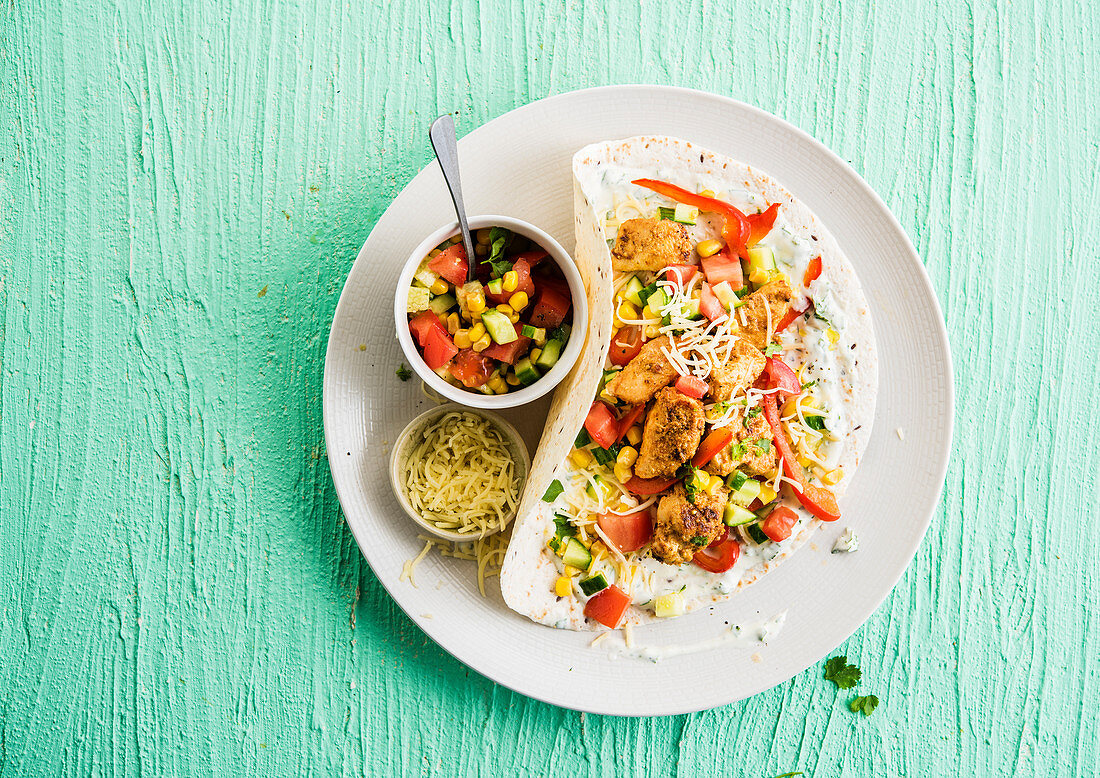Chicken wrap with tomatoes, corn and cucumber salad