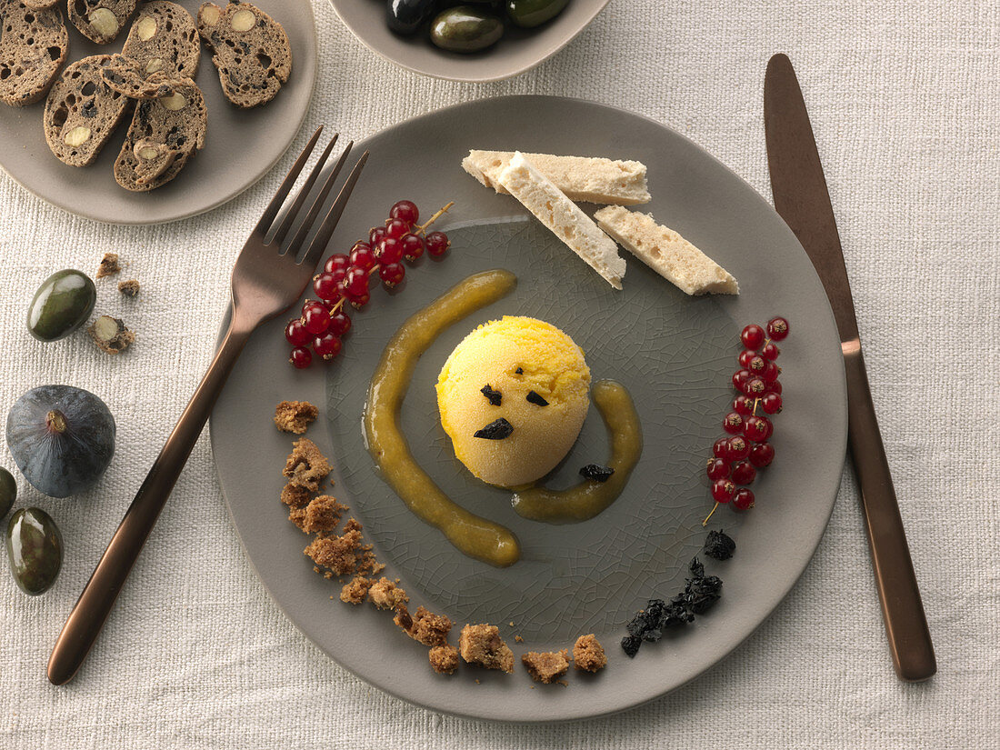 Mango sorbet in olive oil and black olive bread chips