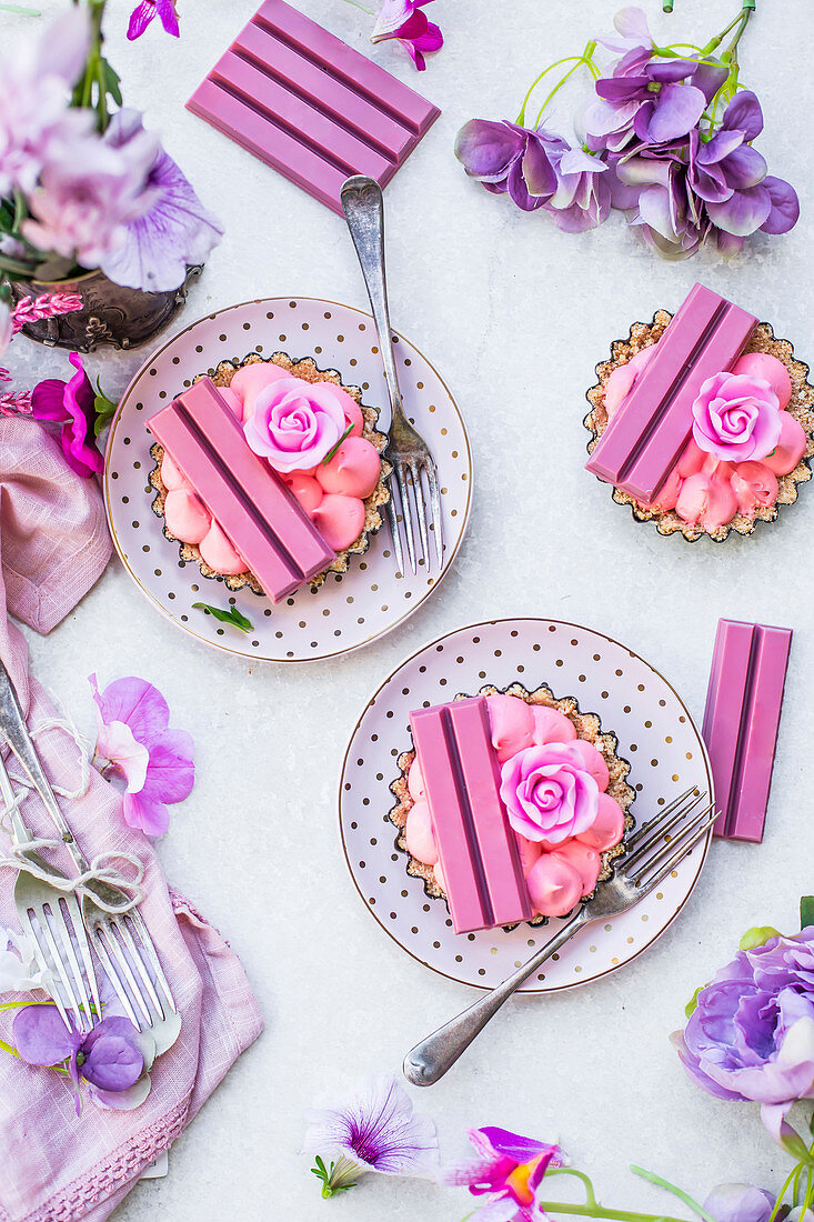 Pink mini cakes with cream filling, ruby chocolate bars and rose petals
