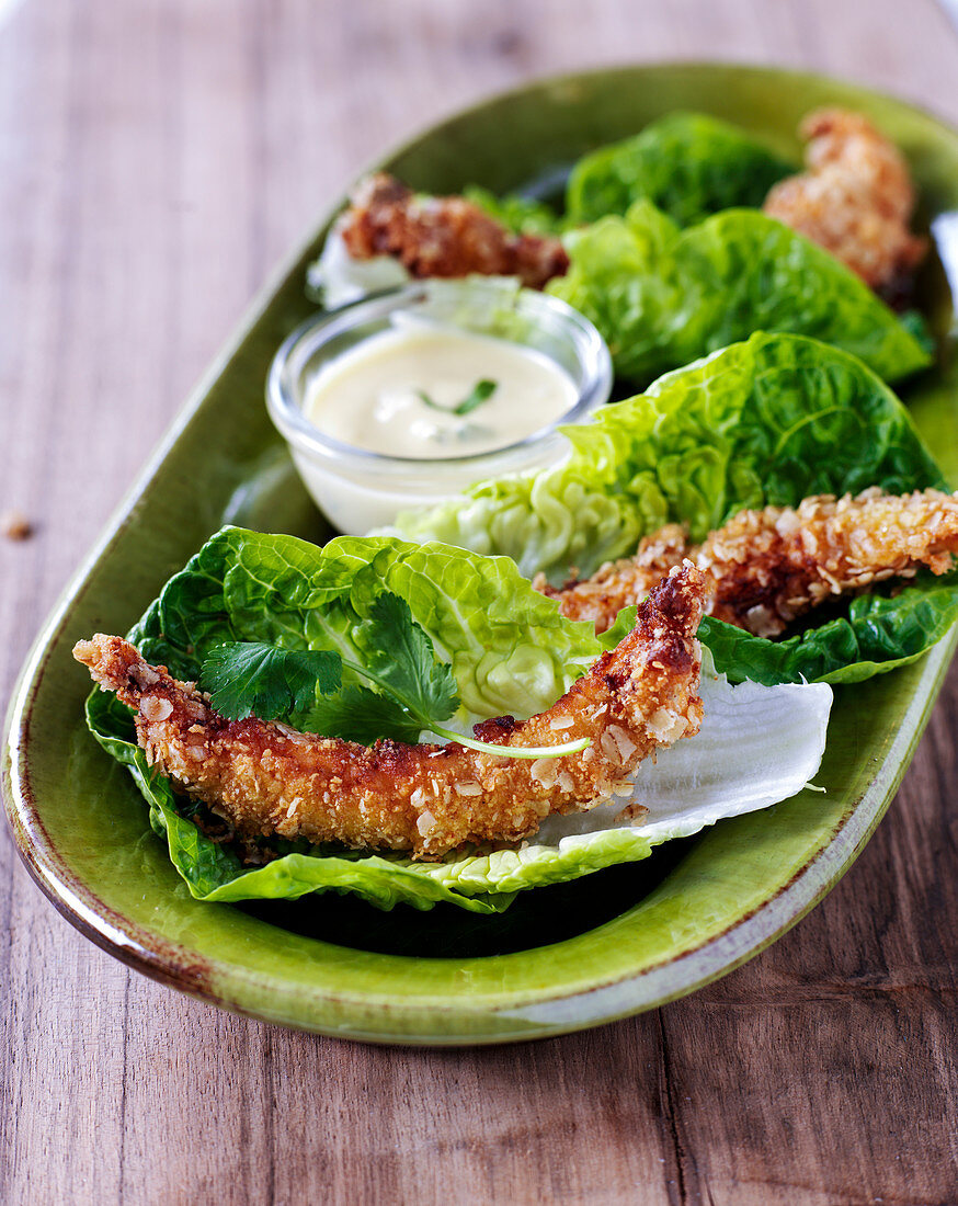 Crispy breaded langoustines on salad leaves with a dip