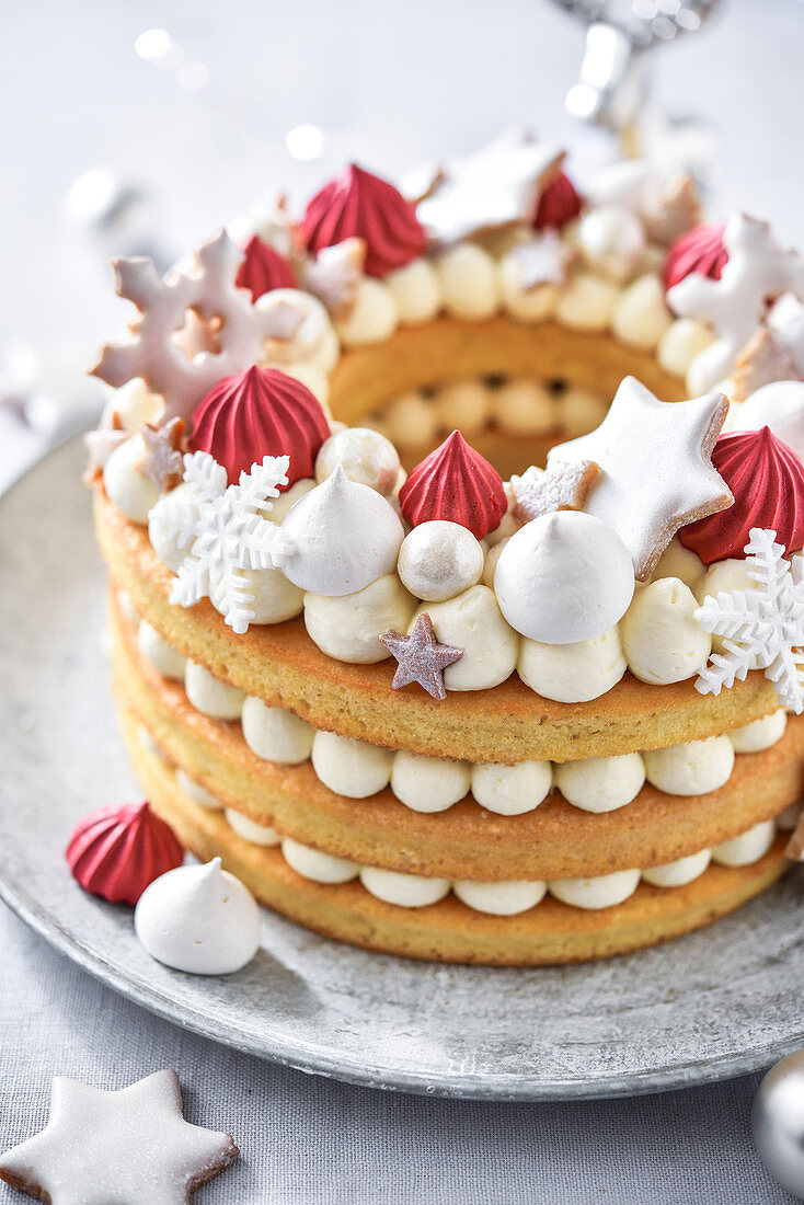 Weihnachtskranzkuchen dekoriert mit Baisertupfen und Plätzchen