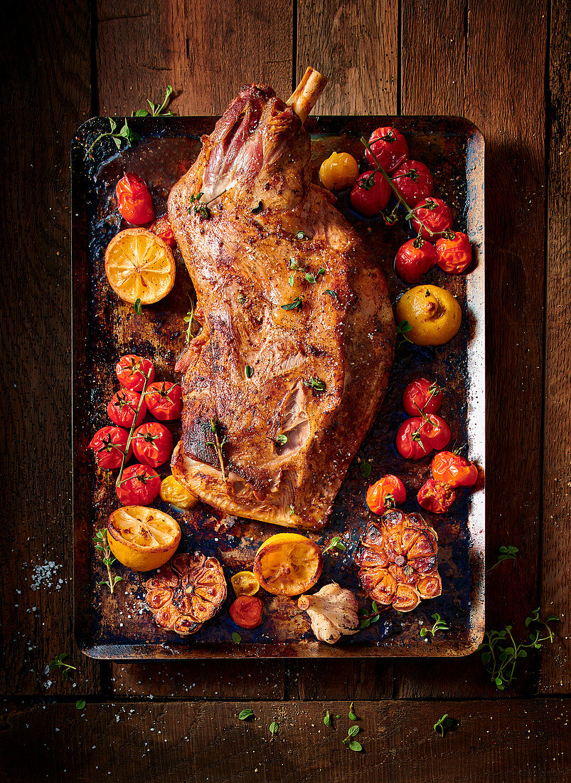 Oven roasted lamb shoulder with garlic, tomatoes and lemons