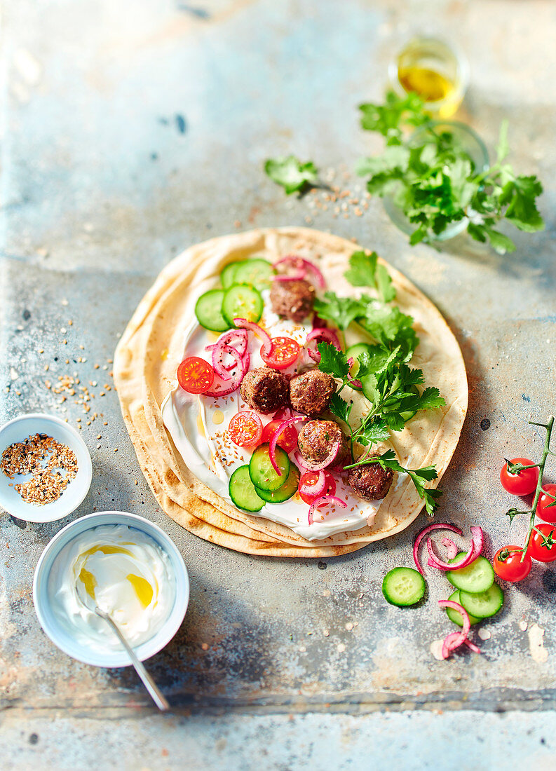 Pita with meatballs, tomatoes, cucumber and yoghurt dip