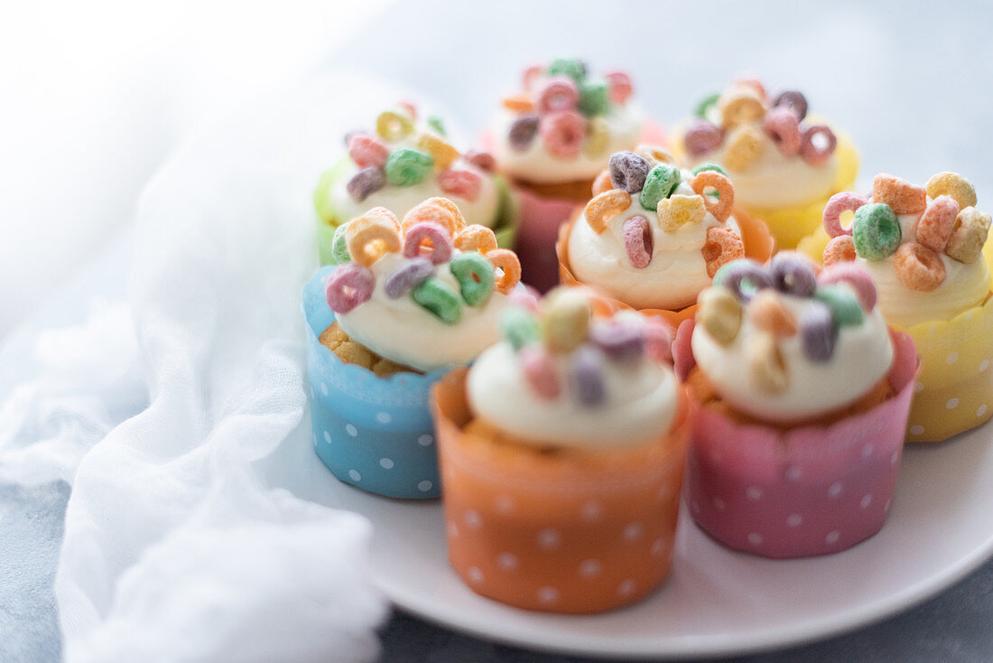Cupcakes decorated with icing and colourful Fruit Loops