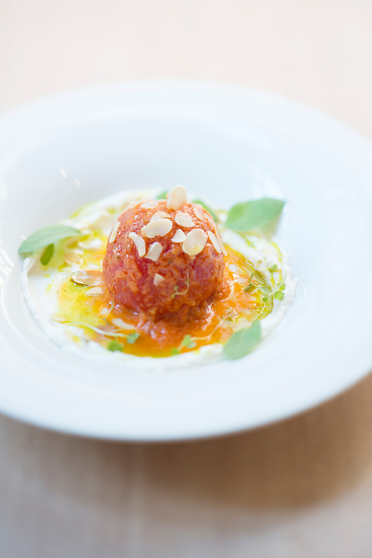 Iced tomato with pepper juice, slivered almonds and herbs