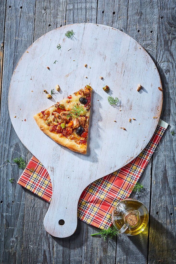 Ein Stück Pizza mit Huhn, Oliven und Gemüse