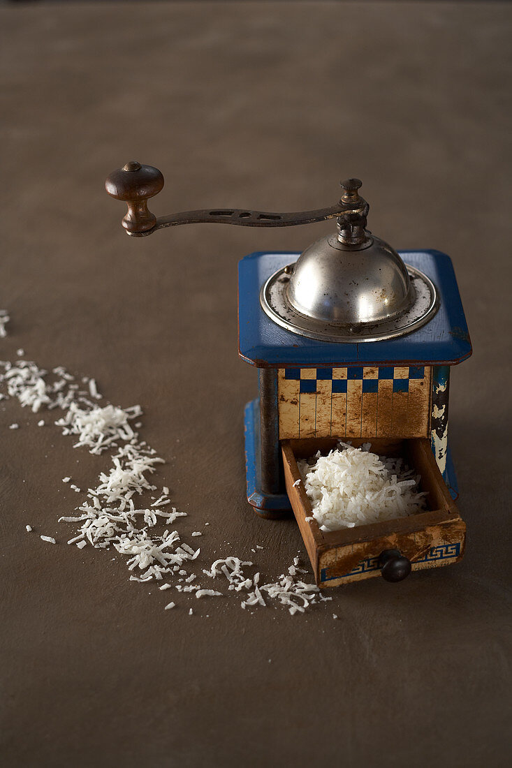 Grated coconut in the drawer of a vintage manual coffee grinder