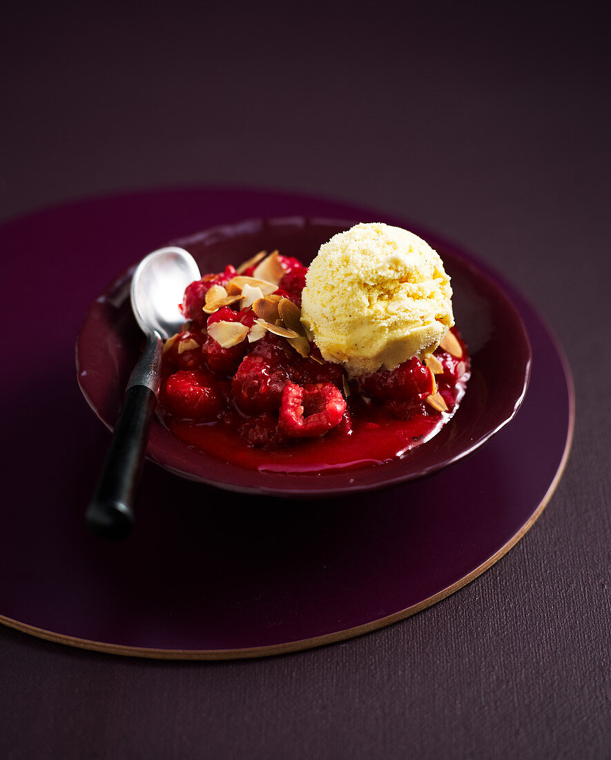 Vanilla ice cream with hot raspberries and almond flakes