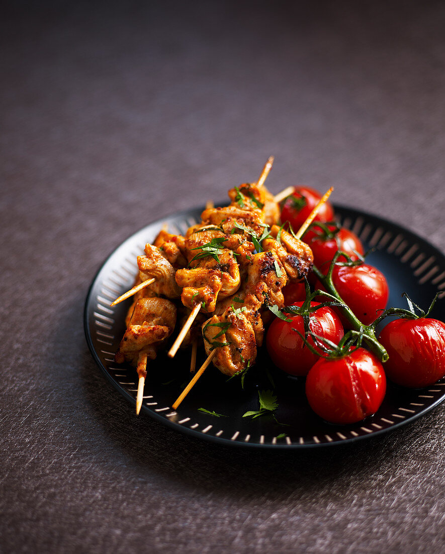 Chicken satay skewers with grilled cherry tomatoes