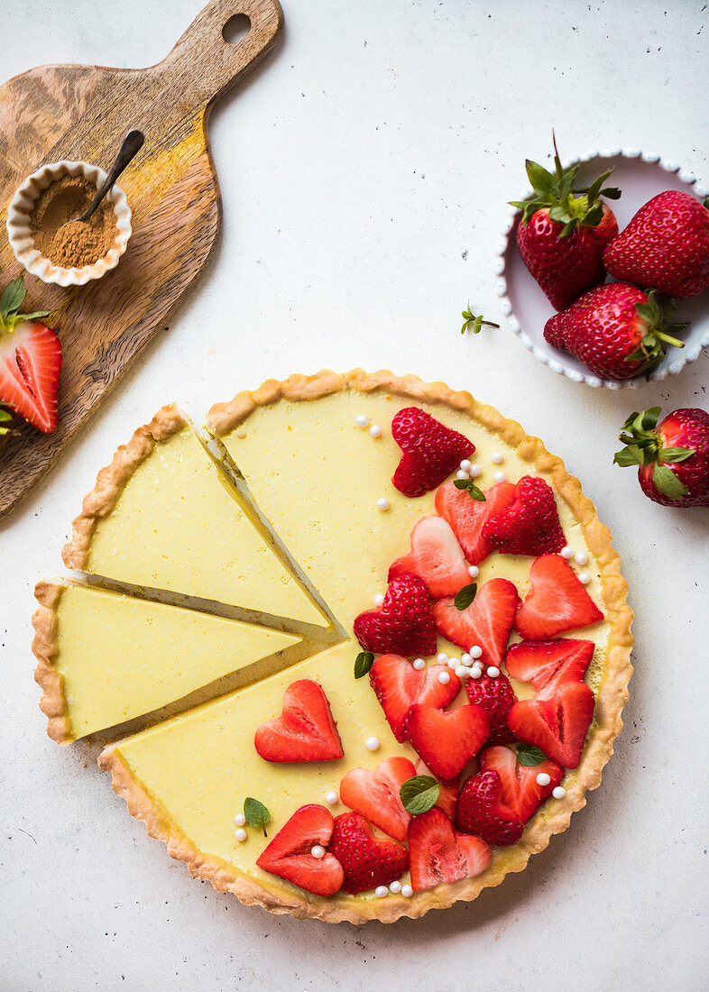 Lemon tart decorated with heart-shaped strawberries