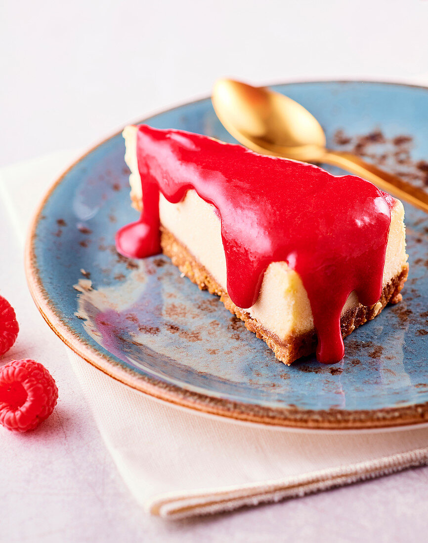 Slice of cheese cake with raspberry coulis