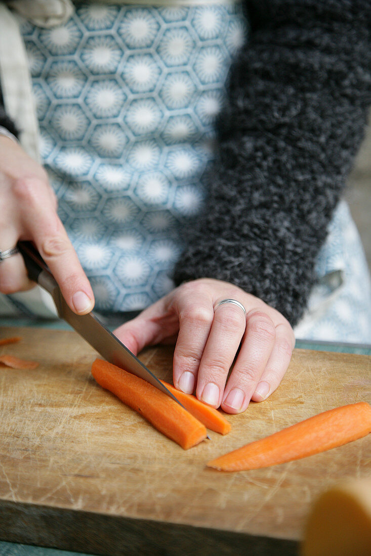 Woman cutting a carrot