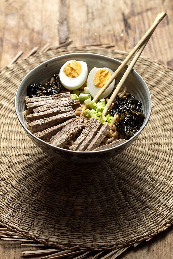 Ramen mit Algen, Ei, Frühlingszwiebeln und Rindfleisch im Schälchen (Japan)