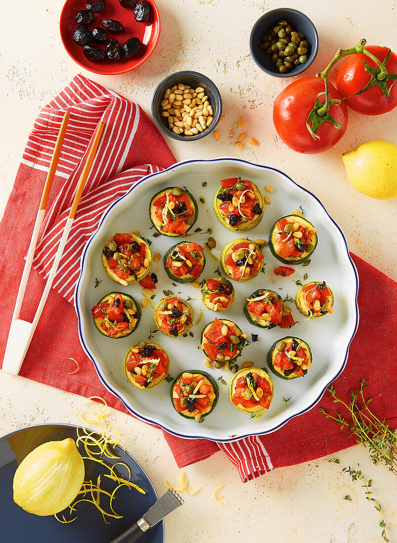 Zucchini-Häppchen mit Tomatenwürfeln, Oliven und Pinienkernen