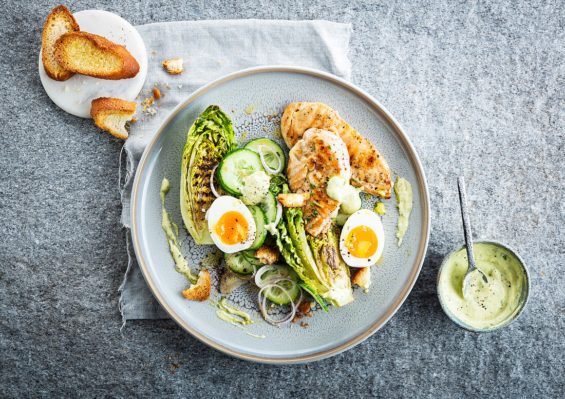 Caesar Salad mit Hühnerbrust, gegrillten Salatherzen, Gurke und Ei