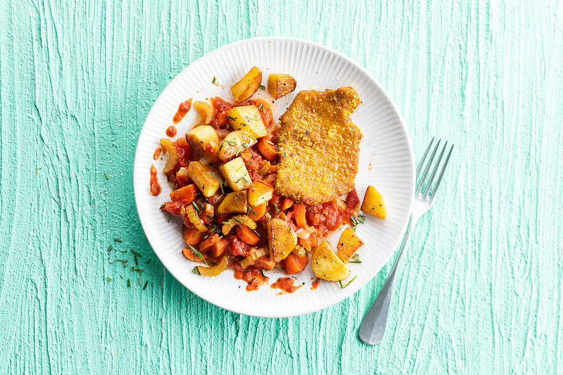 Paniertes Geflügelschnitzel mit Bratkartoffeln, Möhren und Tomaten