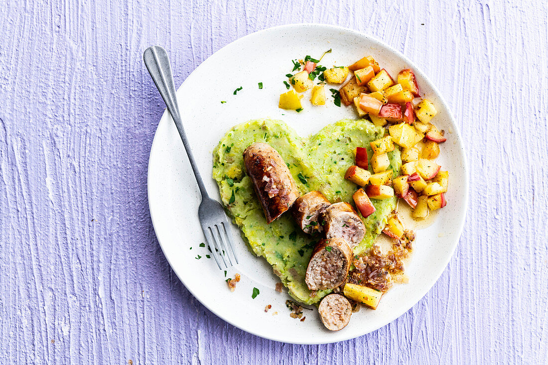 Sausage with mashed brussels sprouts and cooked apple cubes