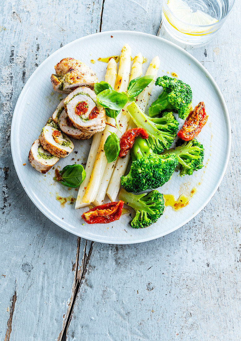 Pesto rolled turkey with white asparagus and steamed broccoli