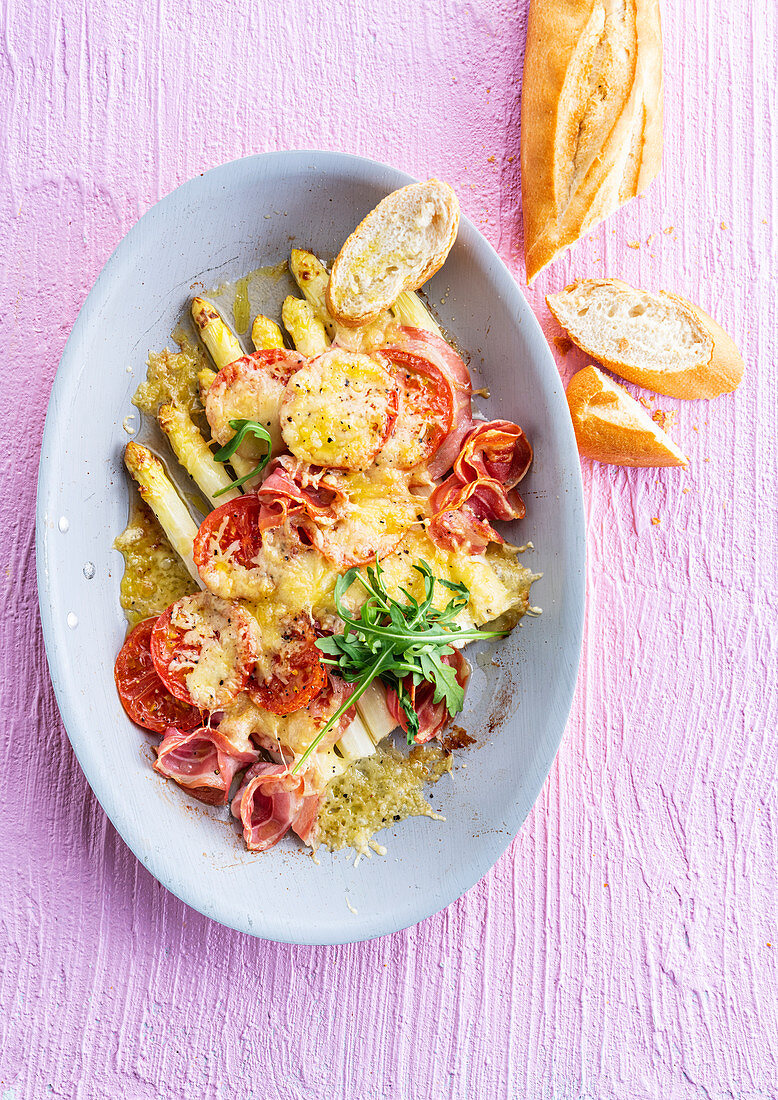White asparagus au gratin with tomatoes and cured ham
