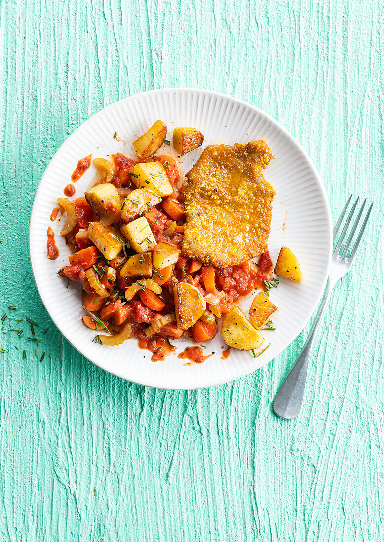 Schnitzel mit Bratkartoffeln und stückiger Tomatensauce