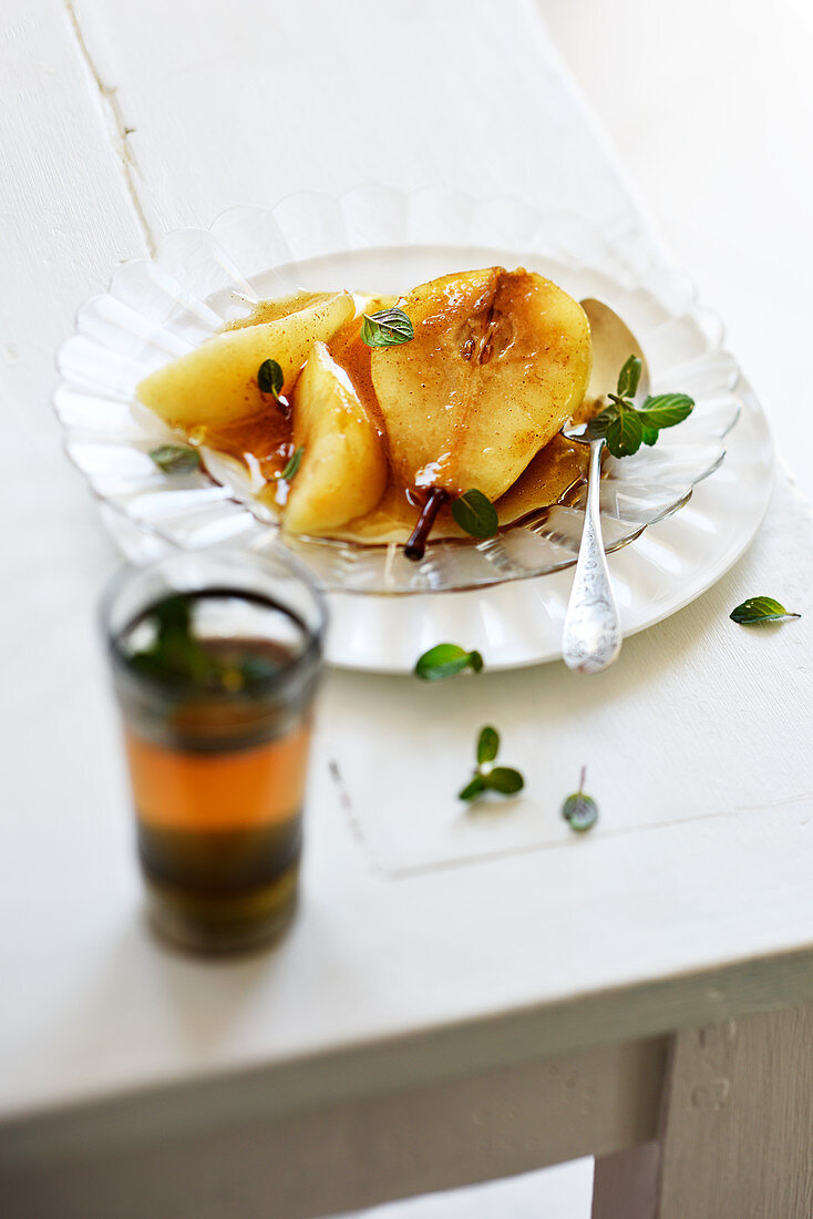 Poached pears with tea and honey syrup and peppermint