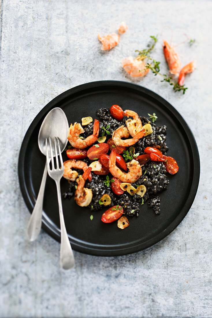 Black risotto with tomato and garlic shrimps