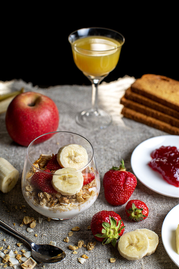 Breakfast with yogurt,cereals,strawberries,bananas and orange juice