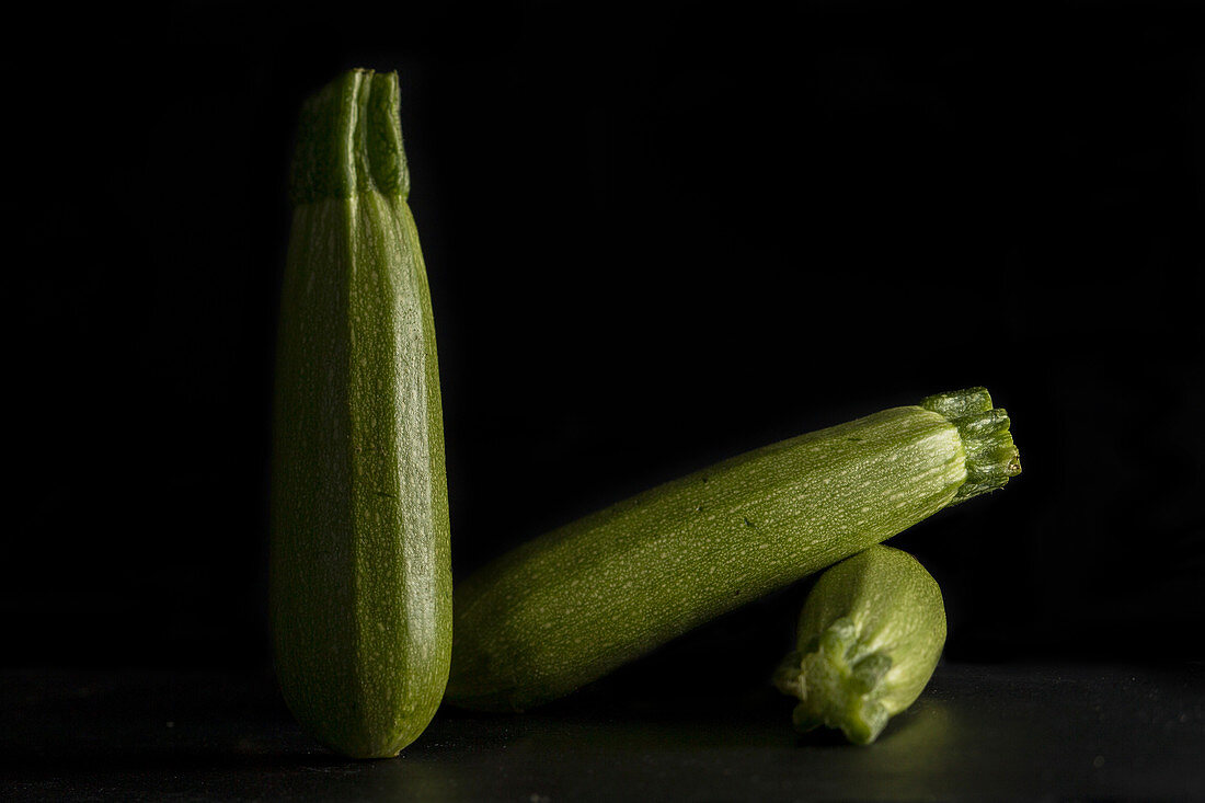 Courgettes against a black background