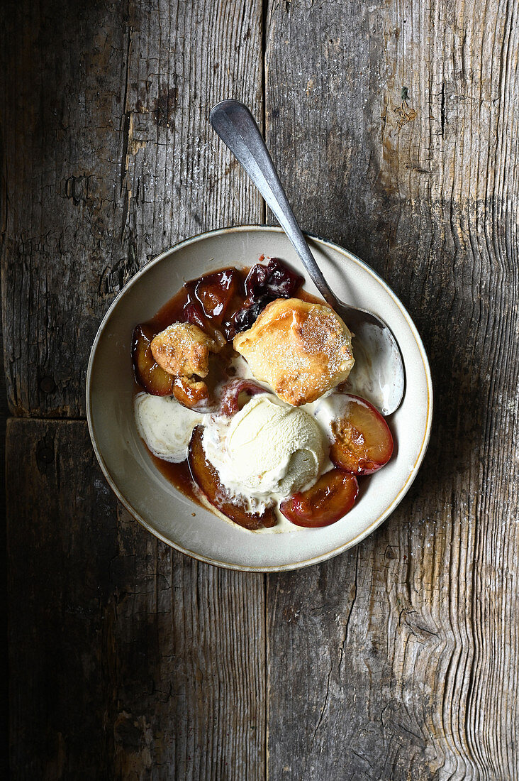 Cobbler with plums and vanilla ice cream