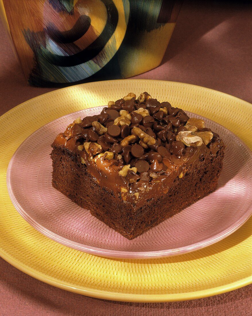 Ein Stück Schokoladenkuchen mit Chocolate Chips und Walnüssen