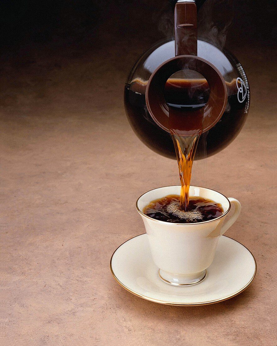 Kaffee wird aus Kanne in Kaffeetasse gegossen