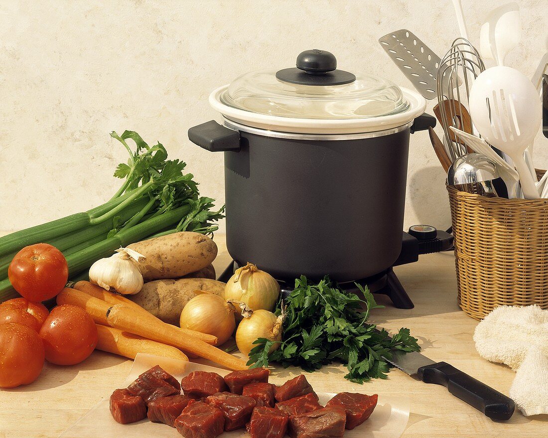 Ingredients for beef stew with pot and utensils