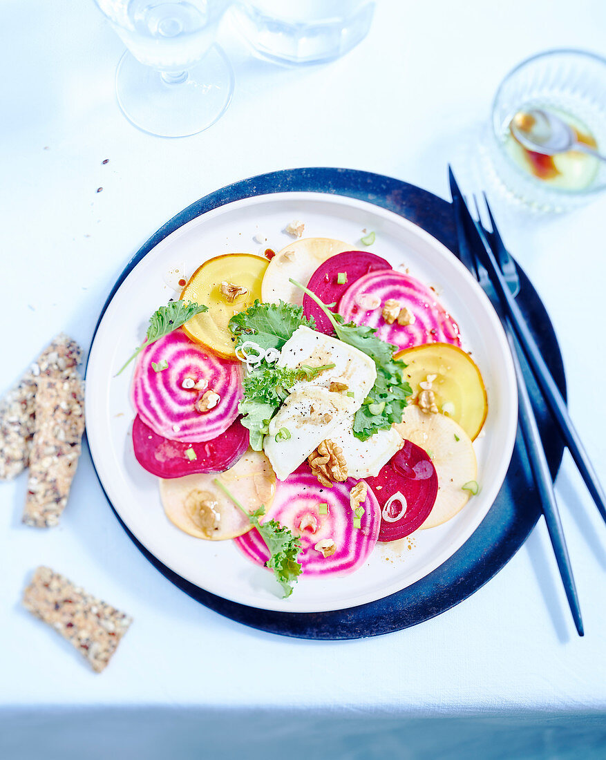 Multicolored beet carpaccio with goat and nuts