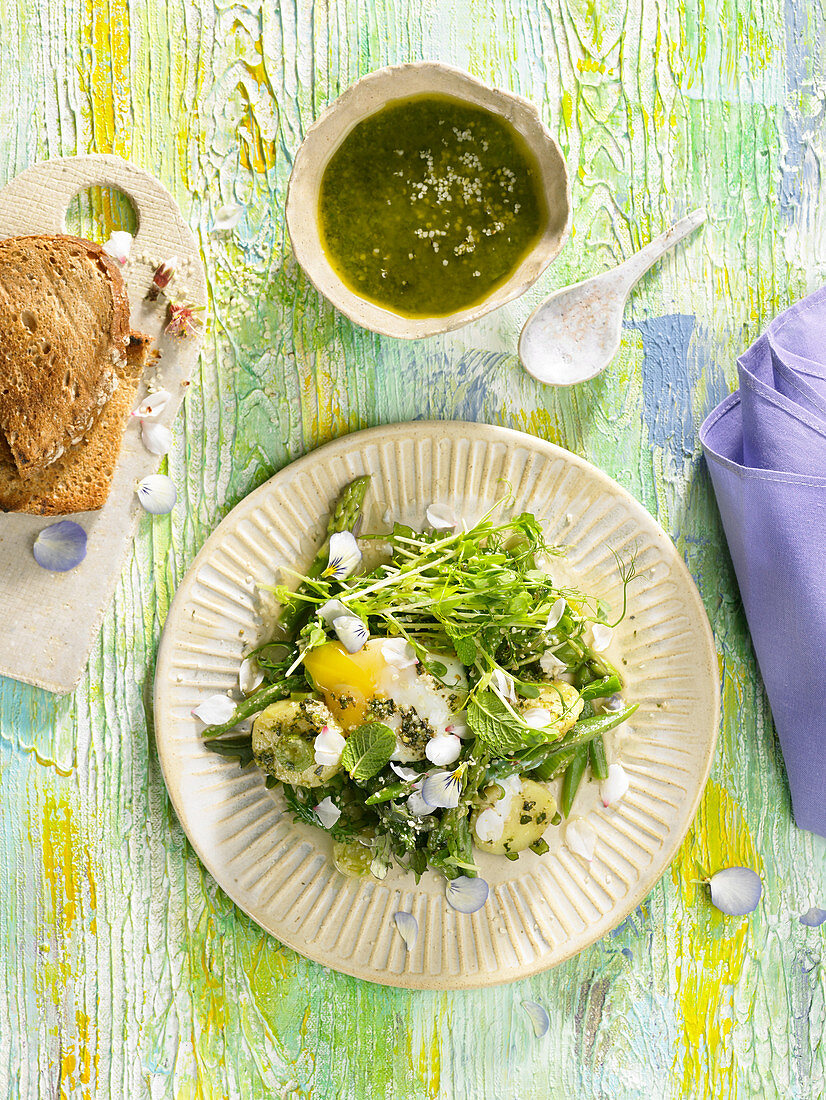 Kartoffelsalat mit grünem Spargel, weichgekochtem Ei, Kräutern und Essblüten