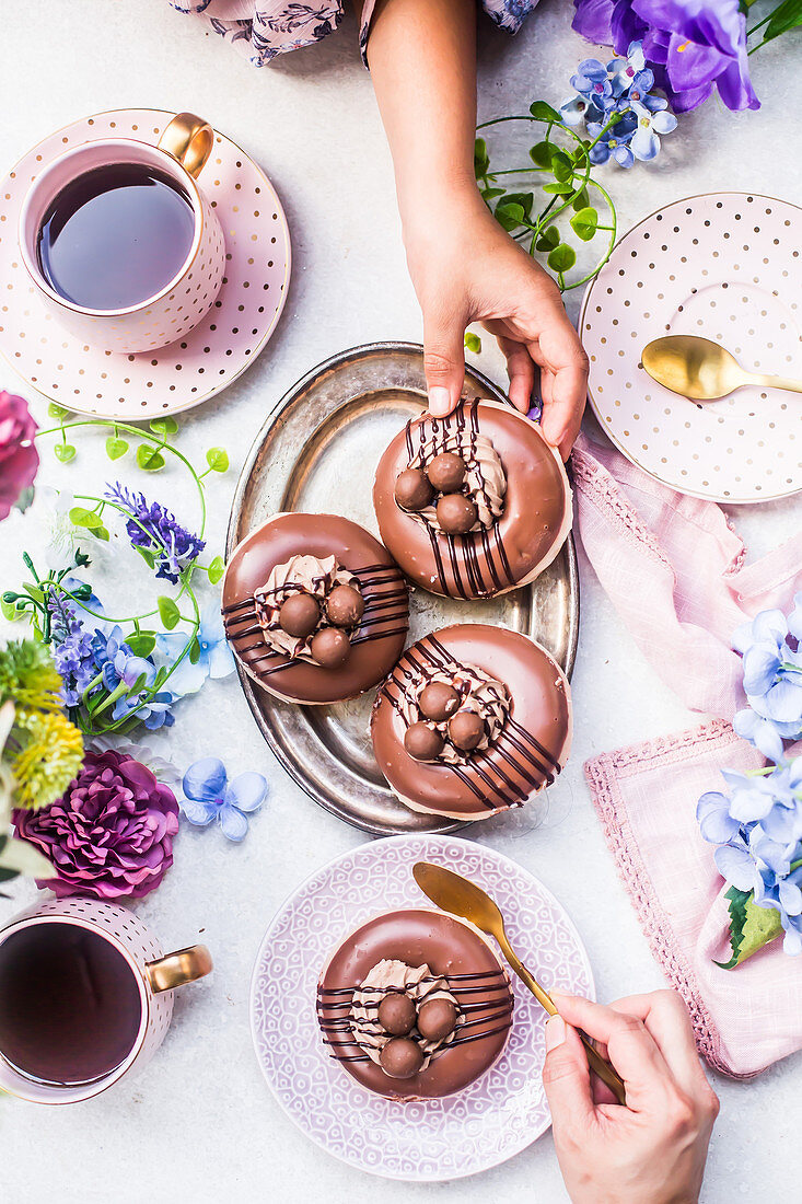 Schokoladen-Donuts dekoriert als Osternester zum Kaffee