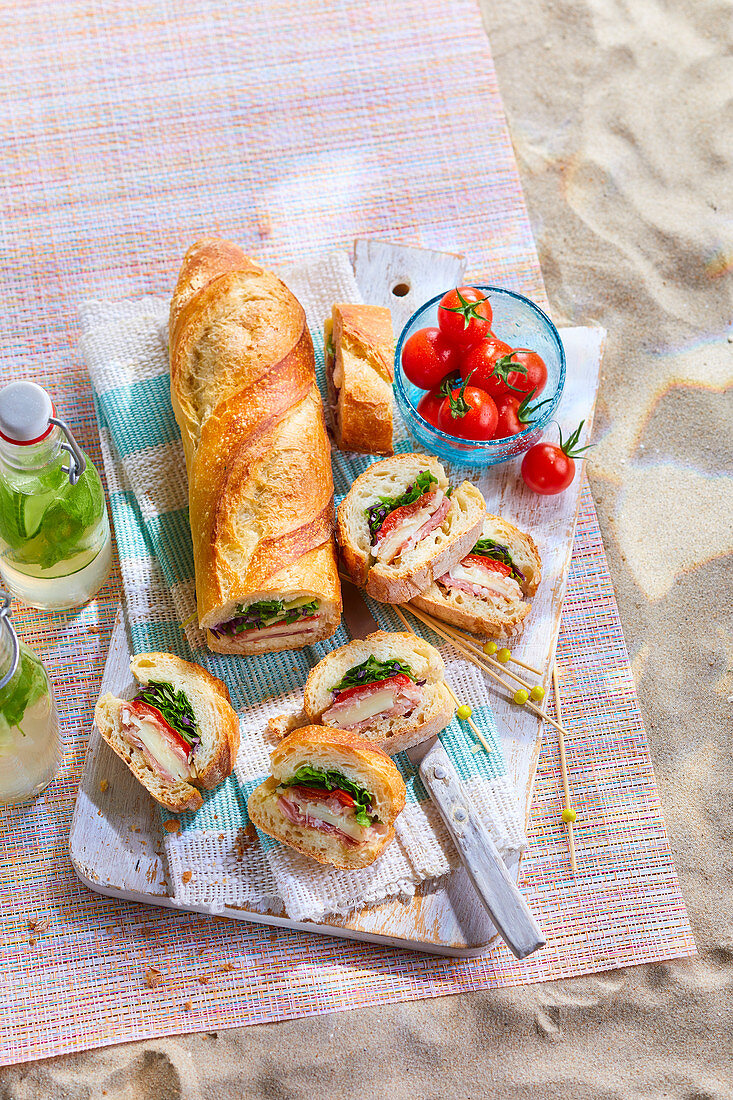 Baguette stuffed with ham, tomato cheese and salad for aperitif, picnic or snacks