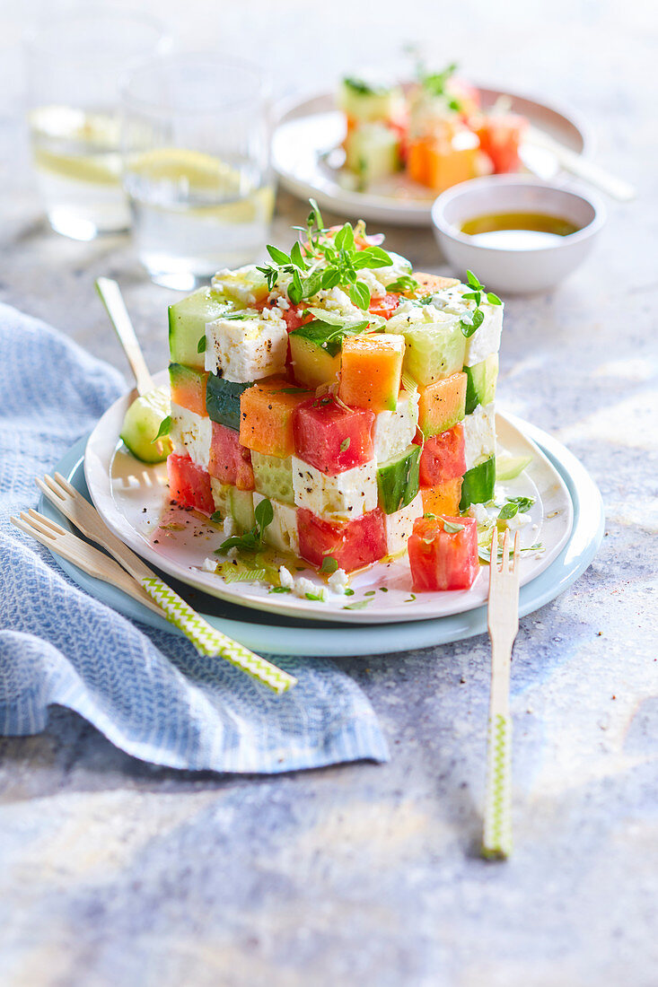 Colorful appetizer made of cubes of vegetables, fruit, and feta