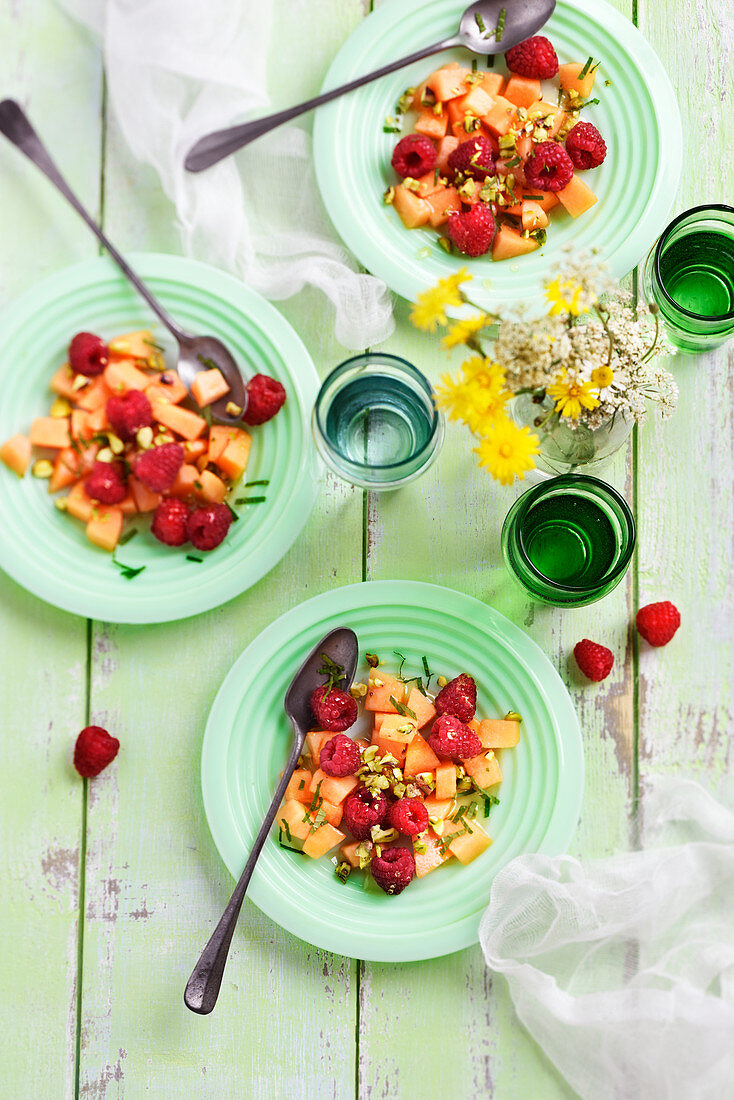 Fruit salad with melon, raspberries, pistachios, mint and honey