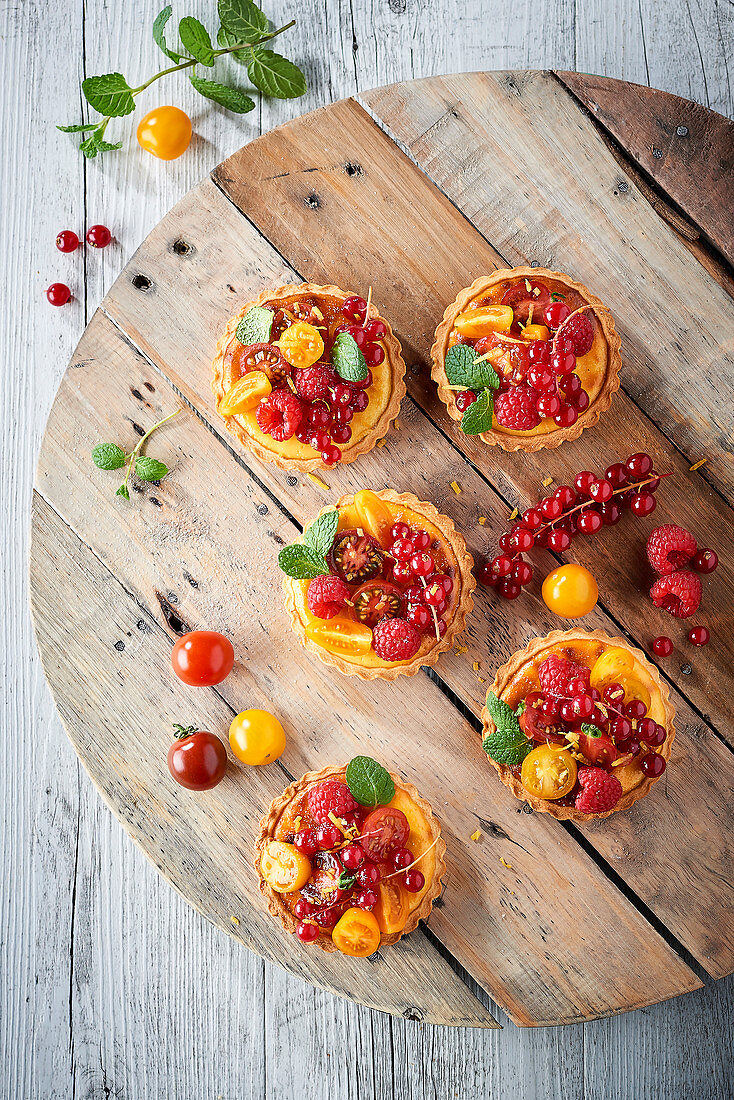 Lemon tarts with red fruits and cherry tomatoes