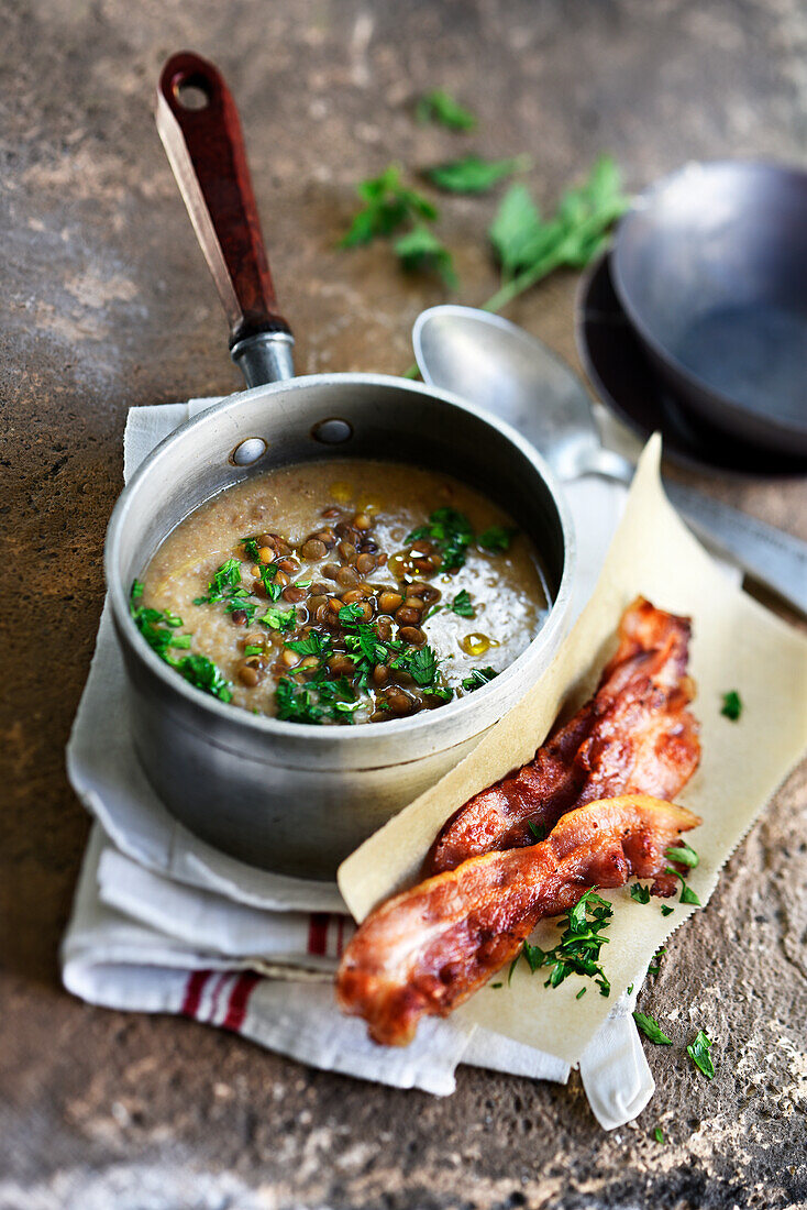 Creamy lentil stew with onions and fried bacon