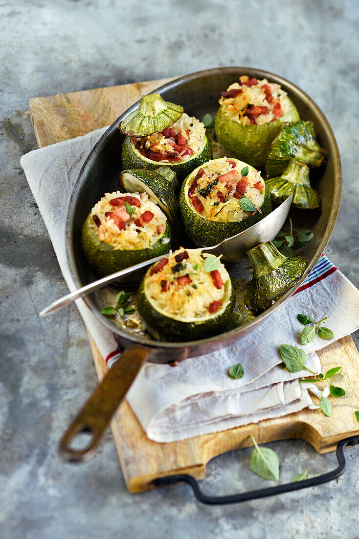 Runde Zucchini, gefüllt mit Reis und Speckwürfeln