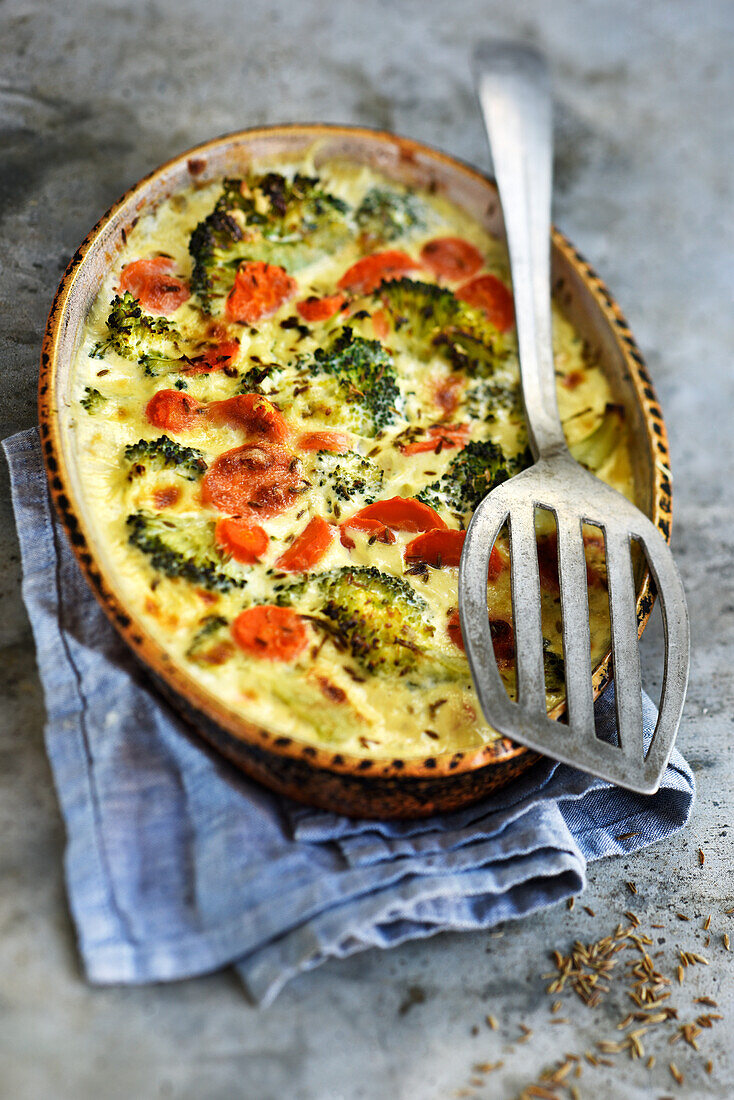 Broccoli gratin with carrots, Emmental cheese and caraway seeds