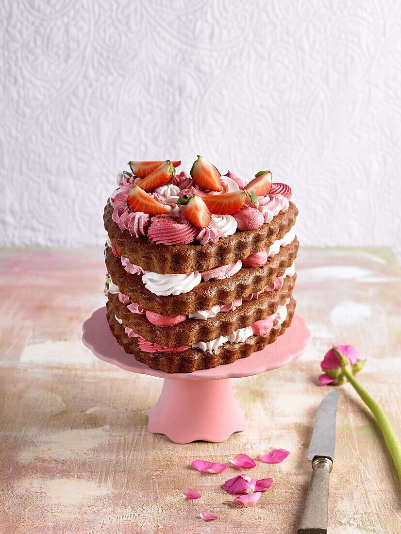 Chocolate layer cake in the shape of a heart with strawberries